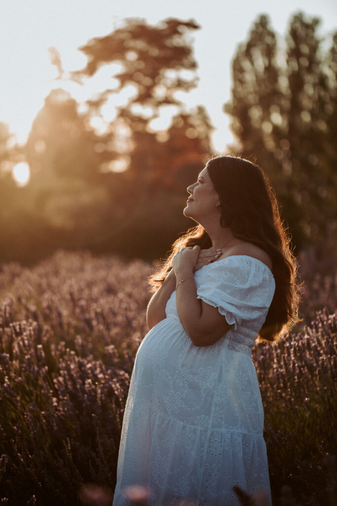 Expecting mother in a light dress at golden hour in a flower field