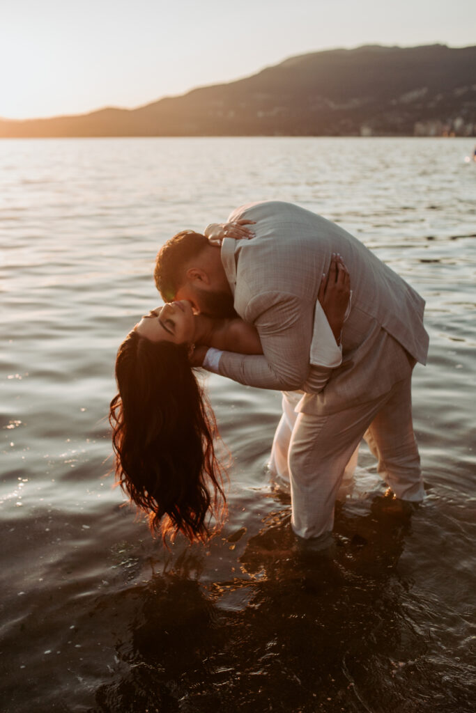 Couple embracing in the ocean at sunset